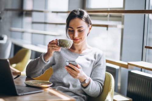 frau-sitzt-cafe-trinkt-kaffee-arbeitet-computer
